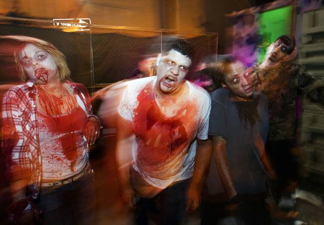 Zombies menace guests going through the Haunted Alley during Halloween in downtown Las Vegas on Wednesday, Oct. 31, 2012.